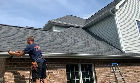 Roofing contractor installing shingles on a New York home.