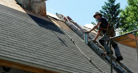 Roofer climbing a ladder during residential roof replacement